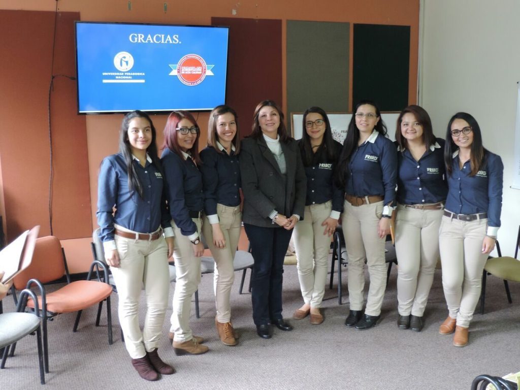 Grupo de 7 Licenciadas en formación, vestidas con pantalón beige y camisa formal azul oscura; en el Centro Profesora Libia Velez Latorre.